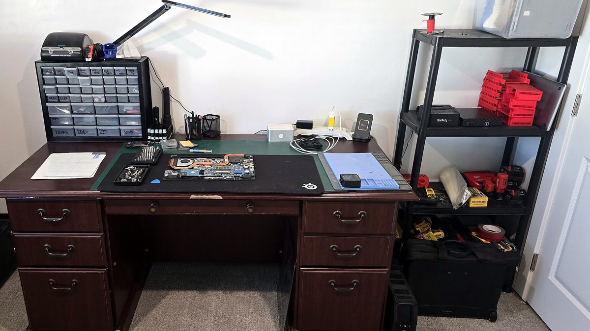 Our repair desk with labelled parts drawers and a laptop being worked on